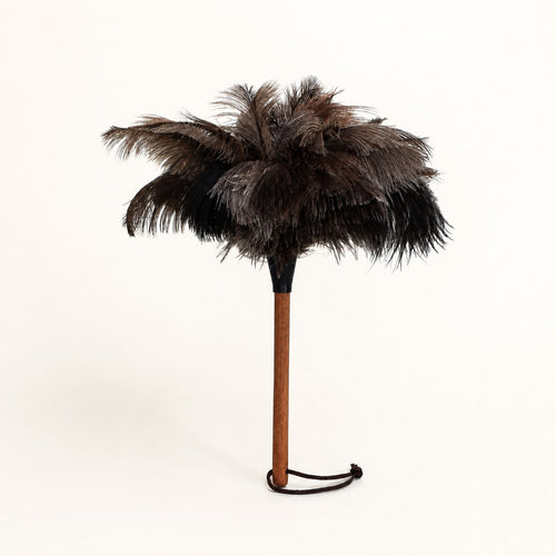 Luvamira Essential Handheld ostrich feather duster standing upright on a warm off-white background.