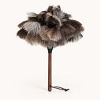 Luvamira Select Handheld ostrich feather duster standing upright on a warm off-white background.
